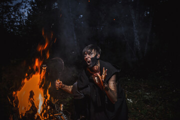 Fototapeta premium Sorcerer with marks on his body in the forest