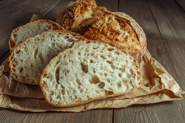 Bread, traditional sourdough bread cut into slices on a rustic wooden background. Concept of...