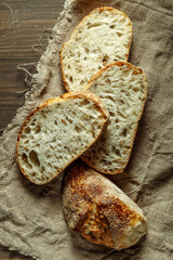 Bread, traditional sourdough bread cut into slices on a rustic wooden background. Concept of traditional leavened bread baking methods. Healthy food.