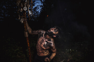 Sorcerer with marks on his body in the forest