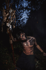 Fototapeta na wymiar Sorcerer with marks on his body in the forest