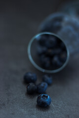 close up of blueberries falling out of a wine glass