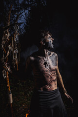Sorcerer with marks on his body in the forest