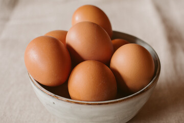 Eggs background. Closeup view of eggs in a bowl on rustic table as background. Organic and healthy food. 