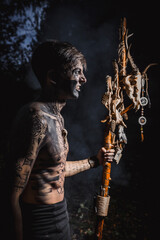 Sorcerer with marks on his body in the forest