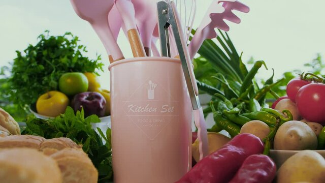 Kamerafahrt an das K&uuml;chenbesteck im eimer, Hintergrund viel frisches Obst und Gem&uuml;se.