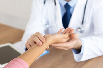 Doctor checking measuring pressure on patient's hand pulse