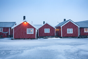 Traditional red wooden houses on the shore of Reine fjord. Beautiful winter scene of Vestvagoy island. Picturesque morning view of Lofoten Islands, Norway, Europe. Life over polar circle.