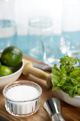 Mojito cocktail ingredients and tools on wooden cutting board