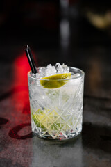 Cocktail with ice and orange liqueur decorated with lime. Making cocktails at home like an expert nightclub barman.