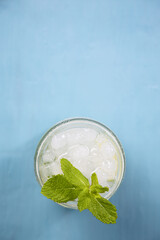 One refreshing mojito cocktail on a blue table. Top view
