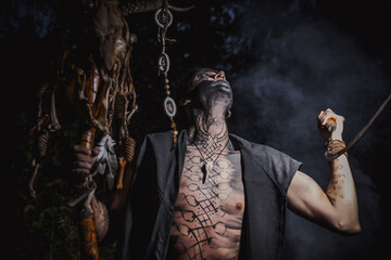 Sorcerer with marks on his body in the forest