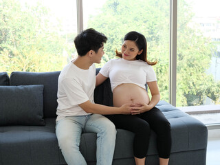Asian pregnant woman and her husband take good care of her.