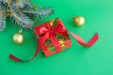 Christmas gift with red ribbon on the green background