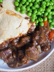 british pub food - steak pie with garden peas 