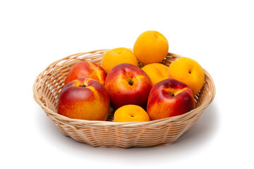 nectarine, peach and plums in a wicker basket on a white background