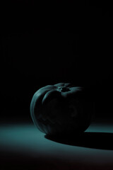 Silhouette in red tones of a carved halloween pumpkin. Dark mode Halloween 2020