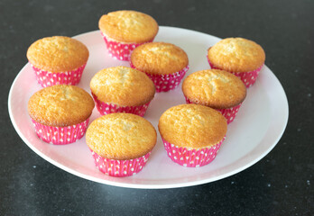 Home baked cupcakes in dark background, pink with dots