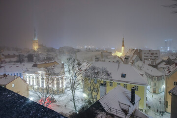 Winter night view from Kohtuotsa viewing platform to historic medieval downtown and modern city of Tallinn, obscured by the heavy snowstorm and creating winter wonderland dreamy look