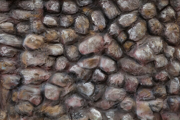 A wall made of cobble stones. The stones are painted with paint.