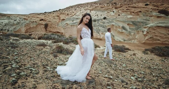 Attractive lady and man standing in front the camera looking straight in amazing landscape view they feeling very romantic