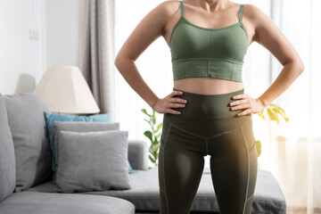 Close up fitness woman in sportwear standing at home