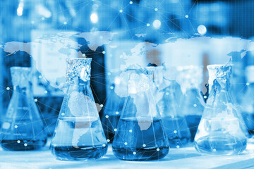 Chemical beaker in laboratory with atomic chart
