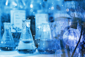 Chemical beaker in laboratory with atomic chart
