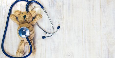 Children's toy and a stethoscope on a light background. Selective focus.
