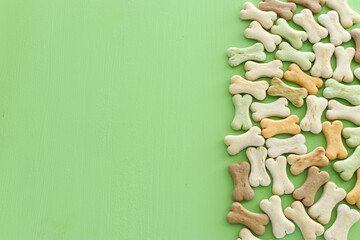 Top view of dog treats over green wooden background