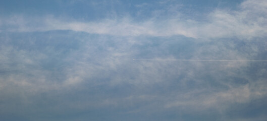 Obraz premium airplane in the blue sky with clouds.