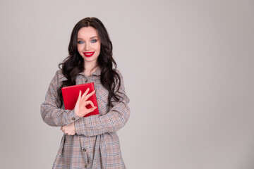 Fototapeta premium Beautiful girl student business women with red notebook on white, grey background.sign of approval