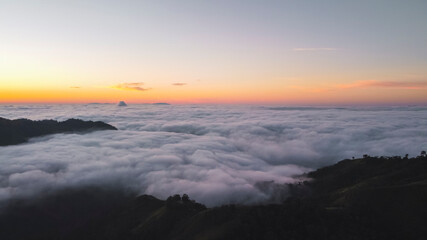 View of a sunrise from a mountain surrounded by clouds