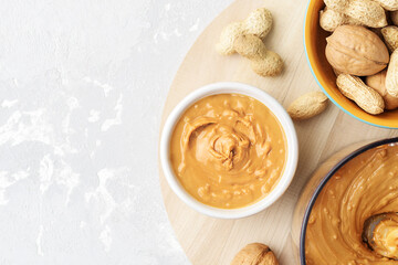 Walnut butter made of peanuts, almonds and walnut on a grey background.