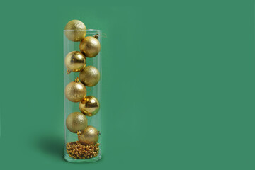 gold Christmas toys in a vase on a green background New Year's layout banner space for text