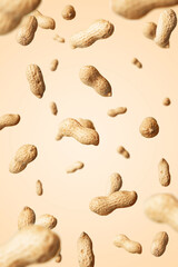 Levitation of raw peanuts on beige background.
