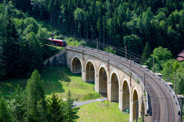 Train on the viaduct over the Adlitzgraben on the Semmering Railway. The Semmering Railway is the oldest mountain railway of Europe and a Unesco World Heritage site.