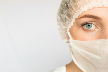 a girl with a medical mask on a white background, a woman doctor, a woman with a beautiful look, hair pinned up. the medicine