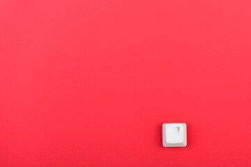 Keyboard key with question mark isolated. White keyboard key on red background. Top view. Close up