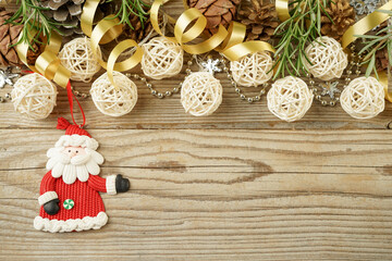 Christmas composition of a Christmas tree toy Santa Claus, garlands and ribbons with Copy space on a wooden background for a greeting card