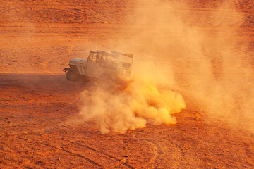 An offroad vehicle used for desert safari is speeding up in desert with aggressive turns that...