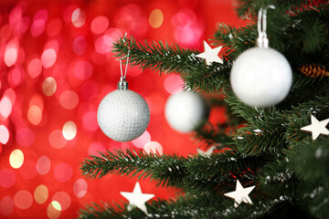 Fototapeta na wymiar Christmas fir tree with ornaments on blurred lights background