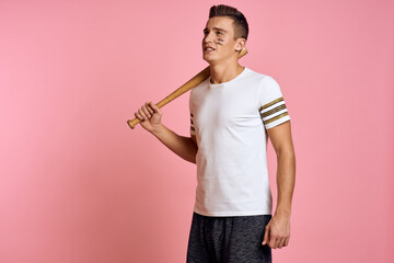 Energetic man with a bat on a pink background T-shirt face make-up black lines aggression model