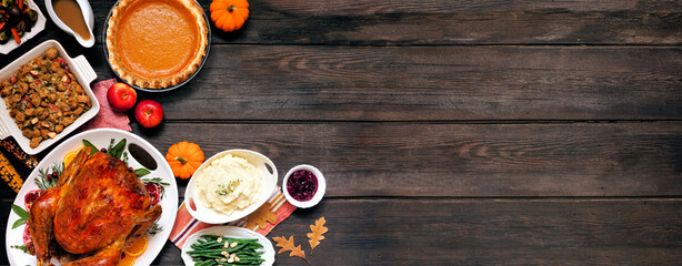 Obraz na płótnie Canvas Traditional Thanksgiving turkey dinner. Top down view corner border on a dark wood banner background with copy space. Turkey, mashed potatoes, dressing, pumpkin pie and sides.