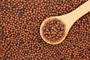 Healthy dried carlin peas in a wooden spoon and forming an abstract background. Very high in protein, low in fat, high in fibre, antioxidants & anthocyanins. Flat lay, top view.