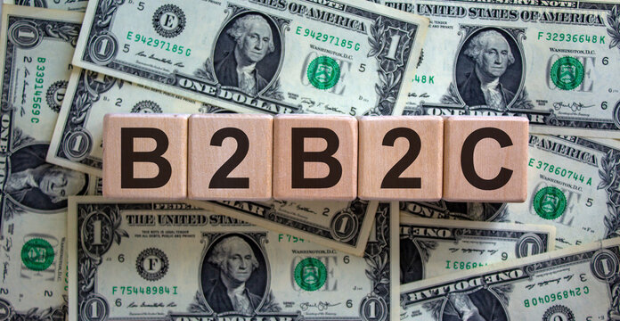 Concept word 'B2B2C', as business to business to customer on cubes on a beautiful background from dollar bills.