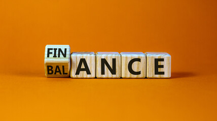 Symbol for finding the right balance in your finance. Turned a cube and changed the word 'finance' to 'balance'. Beautiful orange background. Concept. Copy space.