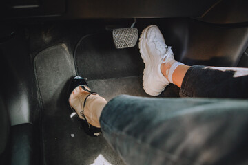woman legs in high-heeled and sneakers shoes - choosing comfort for driving
