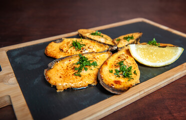 Shellfish mussels with herbs and lemon on the cutting board.