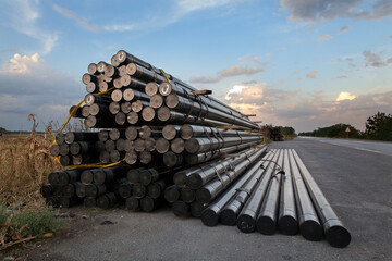 Obraz premium Heap of insulated pipes for natural gas at construction site side a road